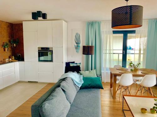 濟夫努夫的住宿－Apartament Gardenia DeLux，客厅配有蓝色的沙发和桌子