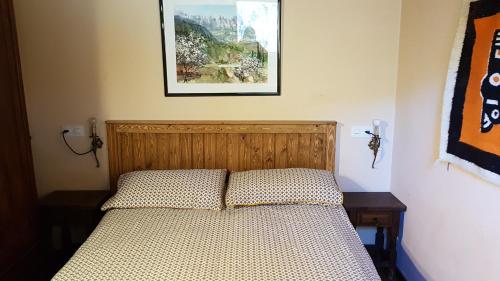 - un lit dans une chambre avec une photo sur le mur dans l'établissement Can Serraima, Casa rural a prop de la Cerdanya, à Navá