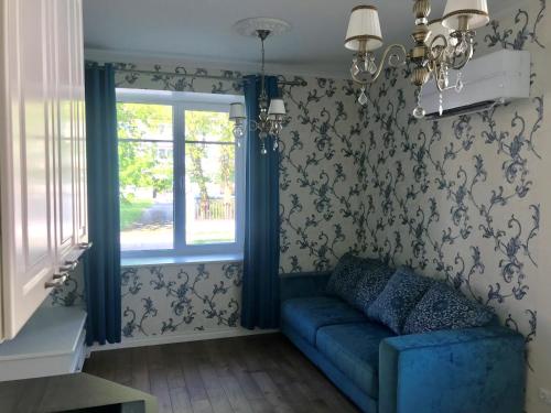 ein Wohnzimmer mit einem blauen Sofa und einem Fenster in der Unterkunft Lahe 9 - apartement in Haapsalu Old Town in Haapsalu
