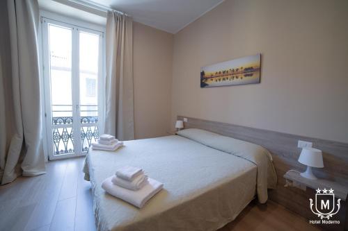 1 dormitorio con 1 cama con toallas en Hotel Moderno, en Lecco