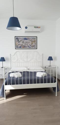 a white bed in a room with two lamps at CASA FLORA in Palermo