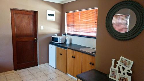 a kitchen with a counter top with a microwave at Blouberg Beach Retreat in Bloubergstrand