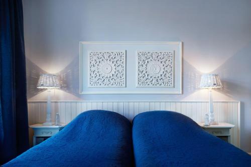 a bedroom with blue sheets and two lamps and a bed at Vondelpark House B&B in Amsterdam