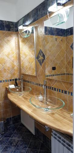 a bathroom with two sinks and two mirrors at CASA FLORA in Palermo