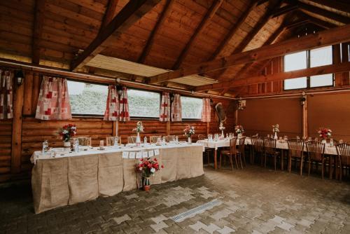 a room with tables and chairs in a barn at Penzion Javorina in Čičmany