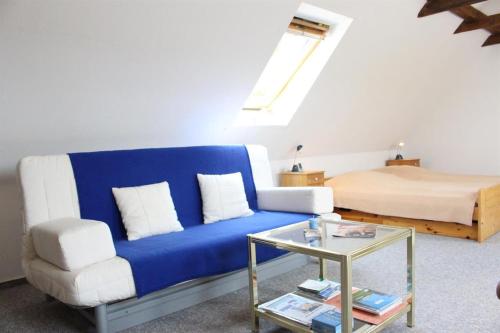 a living room with a blue couch and a bed at Ferienwohnung Lumme in Poppenbüll