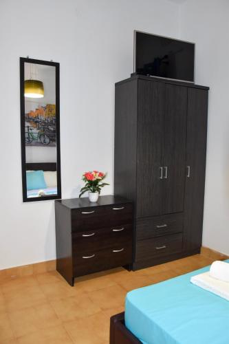 a bedroom with a dresser and a mirror at Afrodites Residence Triopetra in Triopetra