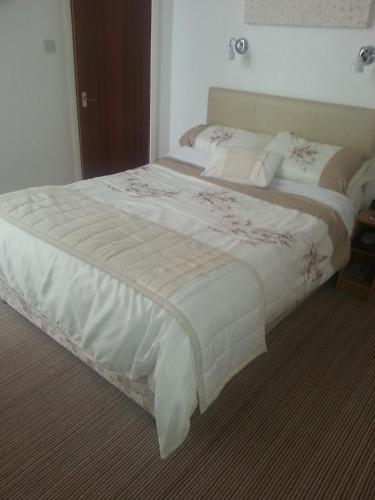 a bedroom with a large bed with white sheets at Morrisy House in Blackpool