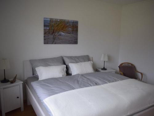 a bedroom with a large white bed with two night stands at Ferienhaus Strandgeflüster in Garding
