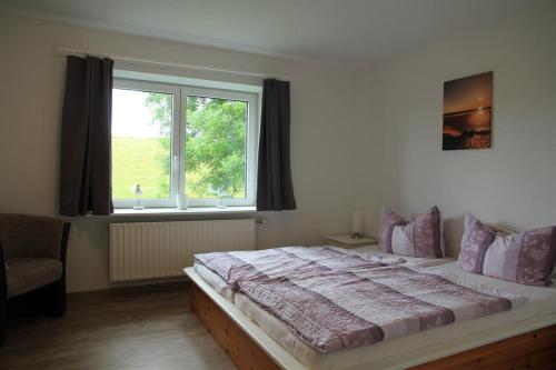 Haus am Meer في Vollerwiek: غرفة نوم بسرير كبير ونافذة
