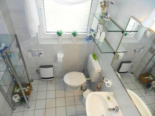 a white bathroom with a toilet and a sink at Diekje Deel in Sankt Peter-Ording