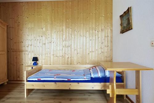 a bedroom with a bed and a wooden table at Ferienhof Land-Idyll in Osterhever