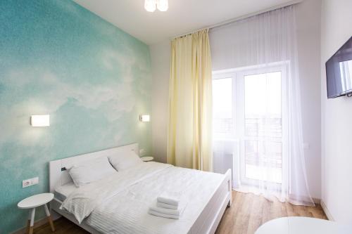 a bedroom with a white bed and a window at BonApart Delux in Lviv
