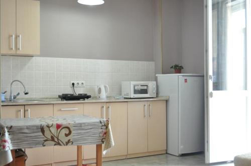 uma cozinha com um frigorífico branco e uma mesa em Zhenis street em Astana