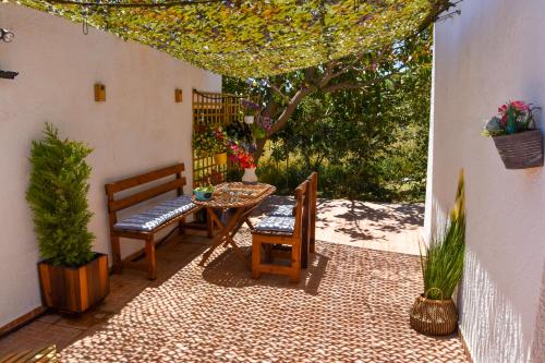 patio z 2 krzesłami, stołem i drzewem w obiekcie Afrodites Residence Triopetra w mieście Triopetra