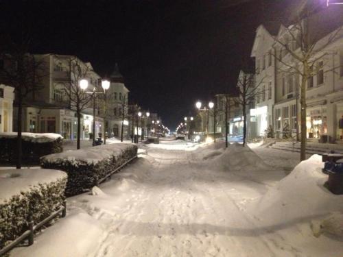 una strada cittadina coperta di neve di notte di Ferienwohnungen Hoffmann a Binz