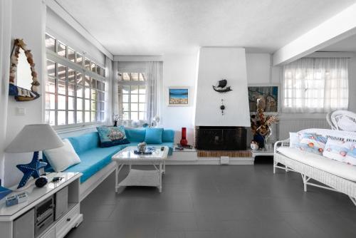 a living room with a blue couch and a fireplace at Vourvourou Villa Mare Verde by Luxlikehome in Vourvourou