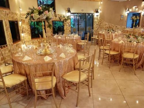 a banquet hall with tables and chairs with flowers at Hotel Cibeles Resort in Heredia