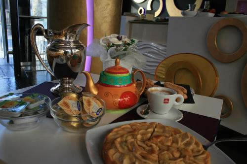 a table with a plate of food and a cup of coffee at Mille e Una Notte in Nuova Gibellina