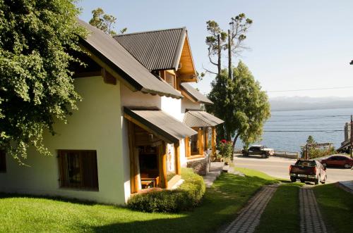 a house on the side of a road next to the water at Don Justo in San Carlos de Bariloche
