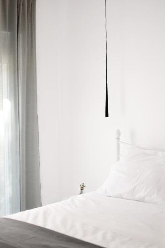 a bedroom with a white bed and a window at ZEN Minimal Luxury Housing Tyros in Tiros