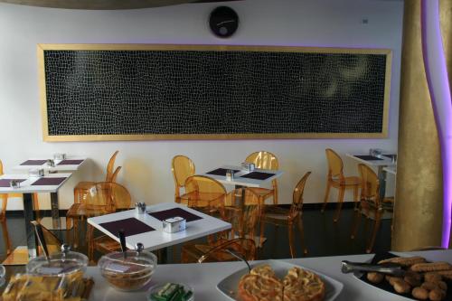 a dining room with tables and chairs and a chalkboard on the wall at Mille e Una Notte in Nuova Gibellina