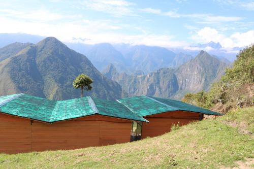 a building with a tree on top of a mountain at Llactapata Lodge overlooking Machu Picchu - camping - restaurant in Salcantay