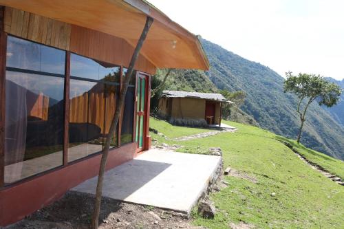 a house on a hill with a view of a mountain at Llactapata Lodge overlooking Machu Picchu - camping - restaurant in Salcantay