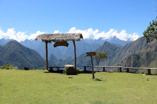 a grass roofed area with a view of a mountain at Llactapata Lodge overlooking Machu Picchu - camping - restaurant in Salcantay
