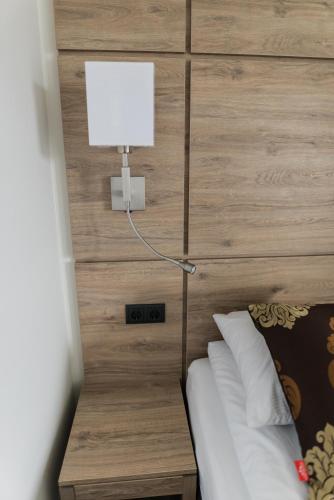 a bedroom with a headboard with a lamp on it at Hotel Duus by Keflavik Airport in Keflavík