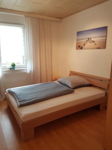 a large bed in a bedroom with a window at Gästewohnung Starsiedel in Lützen