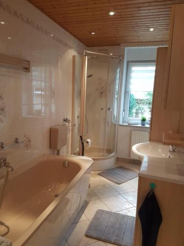a bathroom with a tub and a shower and a sink at Gästewohnung Starsiedel in Lützen