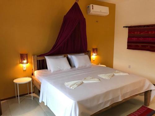a bedroom with a large bed with two towels on it at Villa Aurora in Flecheiras