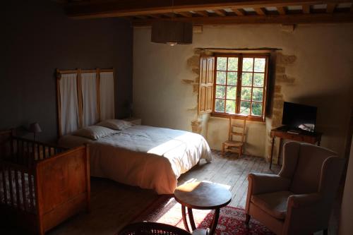 ein Schlafzimmer mit einem Bett, einem Stuhl und einem Fenster in der Unterkunft Manoir de la Ventinière in Marchésieux