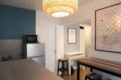 une pièce avec une cuisine avec une table et un réfrigérateur dans l'établissement Studio hyper centre ville Épernay - Champagne, à Épernay