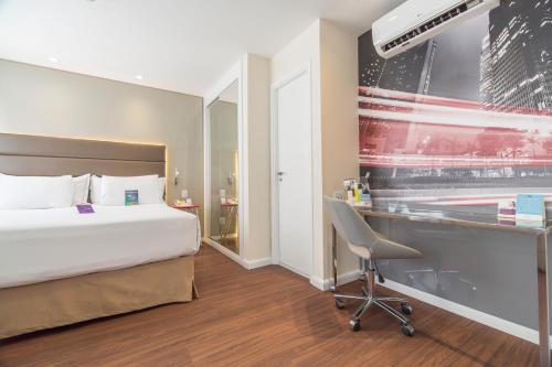 a hotel room with a bed and a desk at Mercure Sao Paulo Vila Olimpia in São Paulo