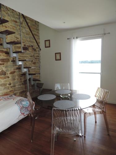 une chambre avec des tables et des chaises et un escalier dans l'établissement Les toiles de mer, à Fouesnant