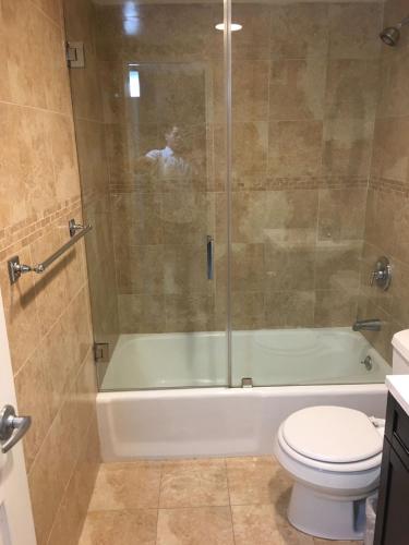 a bathroom with a shower and a toilet and a tub at Tides Apt on Hollywood Beach in Hollywood