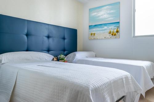 duas camas num quarto com uma cabeceira azul em New Modern City View Apartment - PH Quartier Del Mar na Cidade do Panamá
