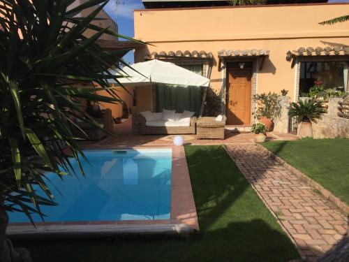 une villa avec une piscine en face d'une maison dans l'établissement Casa Gle, à SantʼAndrea