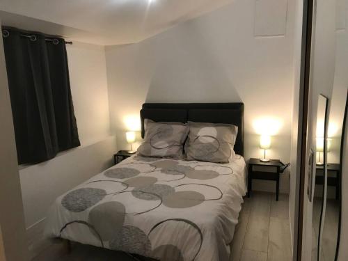 een slaapkamer met een bed en twee lampen op twee tafels bij Dépendance cosy dans le Vexin, terrasse et jardin in Us