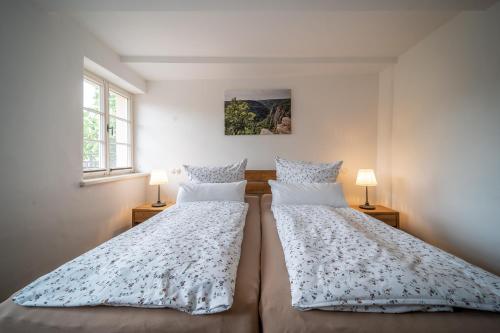 two beds in a bedroom with two lamps at Ferienwohnungen Finkenherd 5 in Quedlinburg