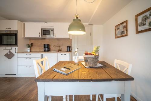 a kitchen with a wooden table with a bowl of fruit on it at Ferienwohnungen Finkenherd 5 in Quedlinburg