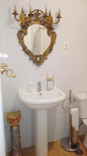 a bathroom with a sink and a mirror on the wall at Império Romano Guest House in Beja