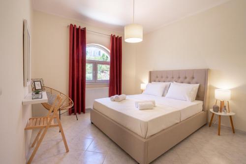 a bedroom with a bed and a window with red curtains at Hill House Koskinou, Rhodes in Koskinou