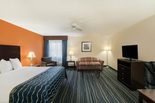 a hotel room with a bed and a flat screen tv at Comfort Inn & Suites in Brentwood
