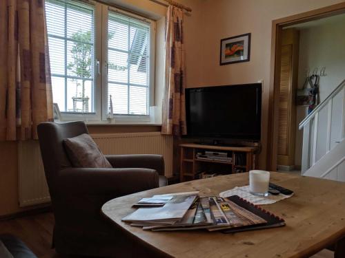 a living room with a coffee table and a television at Ferienhaus Janik in Friedrichskoog