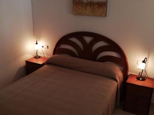 a bedroom with a large bed with two night stands at Parquemar VIII Solo Familias Serviplaya in Xeraco