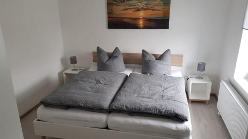 een slaapkamer met een bed met kussens erop bij Kreide & Meer in Sassnitz