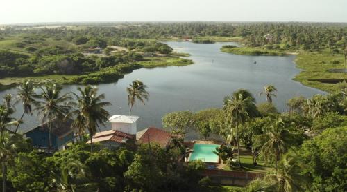 an aerial view of a lake with palm trees at Casa na Lagoa in Paracuru
